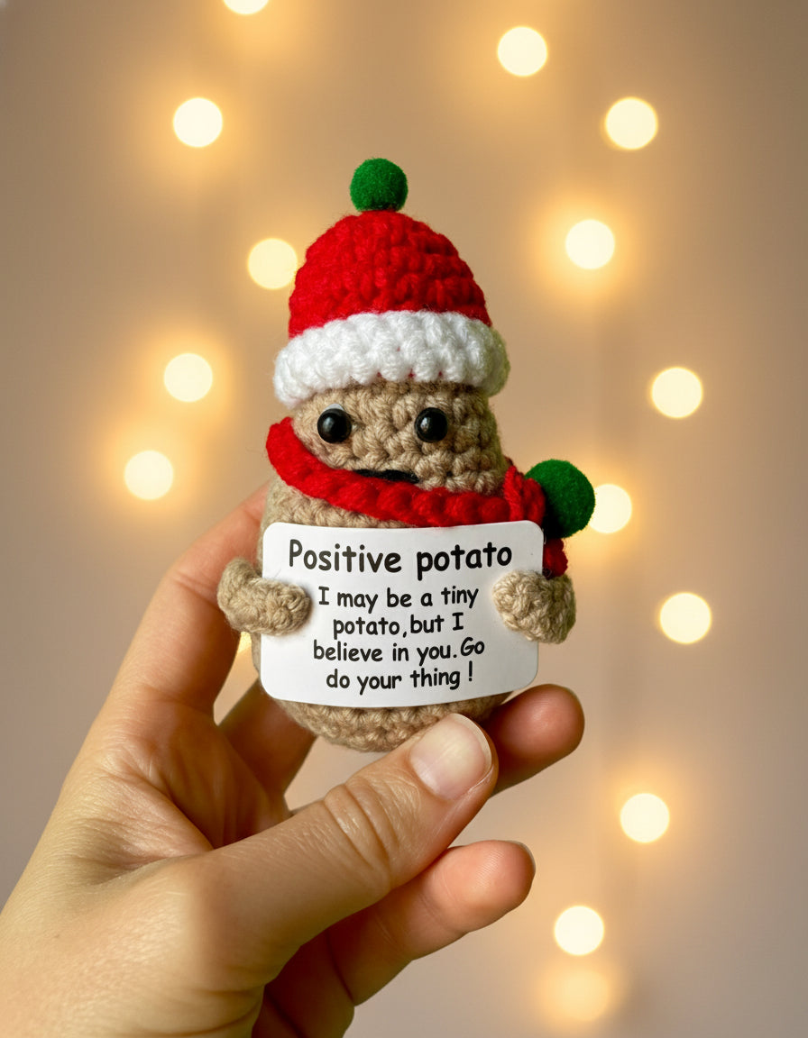 Positive Potato Weihnachts-Edition in der Hand gehalten mit Lichterketten in dem Hintergrund